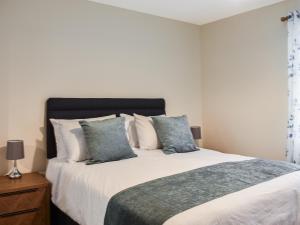 1 dormitorio con 1 cama grande con sábanas y almohadas blancas en Rycon en Turriff