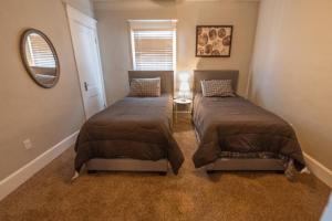a bedroom with two beds and a mirror at Indy 4-Bedroom Haven: Your Perfect Retreat in Indianapolis