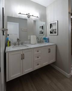 a bathroom with two sinks and a large mirror at Indy 4-Bedroom Haven: Your Perfect Retreat in Indianapolis