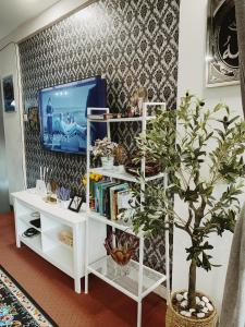 een woonkamer met een tv en een witte boekenplank bij Belle Wardah (Muslim Friendly) Homestay in Bentong