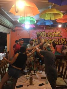 un grupo de personas dándose la mano en una mesa en PHU QUOC BACKPACKER, en Phu Quoc