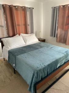 Un dormitorio con una cama con una manta azul. en John’s Place, en Grand Turk