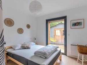een slaapkamer met een bed en een groot raam bij Maison Biscarrosse Plage, 4 pièces, 8 personnes - FR-1-521-232 in Biscarrosse