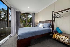 una camera da letto con un letto e una grande finestra di Emerald Hub 1 and 2 a Emerald Beach