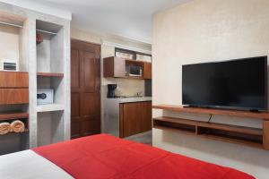 a bedroom with a flat screen tv on a wall at Casa Toloc Tulum in Tulum