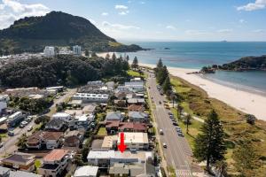 an aerial view of a beach with houses and a road at 36 Marine - Unparalleled beachfront luxury in Mount Maunganui