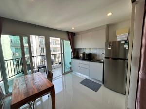 a kitchen with a table and a stainless steel refrigerator at Mantra Beach condo Mae Phim By AA in Ban Tha Fat