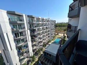 - une vue aérienne sur un immeuble d'appartements avec une piscine dans l'établissement Mantra Beach condo Mae Phim By AA, à Ban Tha Fat