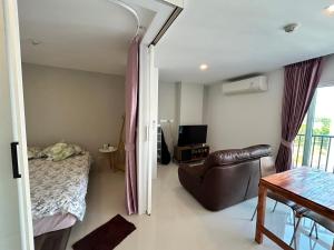 a bedroom with a bed and a chair and a table at Mantra Beach condo Mae Phim By AA in Ban Tha Fat