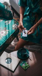 Una mujer con un vestido verde sentada en una mesa. en Madi Paidi Bangkok, Autograph Collection, en Bangkok