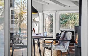 a dining room with a table and a fireplace at Lovely Home In Jgerspris With Wifi in Jægerspris