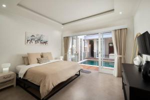 a bedroom with a bed and a swimming pool at Villa Bella Rose Canggu in Canggu