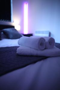 uma pilha de toalhas sentadas em cima de uma cama em Leeds City Centre Apartment em Leeds