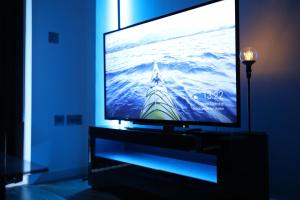 a flat screen tv sitting on a stand in a room at Leeds City Centre Apartment in Leeds