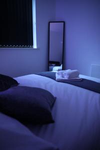 um quarto com 2 camas e uma luz azul em Leeds City Centre Apartment em Leeds