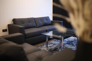uma sala de estar com um sofá e uma mesa de café em vidro em Leeds City Centre Apartment em Leeds
