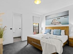 a white bedroom with a large bed with blue pillows at Laguna Rye in Rye