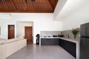 a large kitchen with a couch and a counter top at Villa Bella Rose Canggu in Canggu
