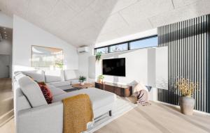HemmetにあるCozy Home In Hemmet With Wifiの白いソファとテレビのあるリビングルーム
