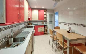 uma cozinha com armários vermelhos e uma mesa de madeira em Stunning Apartment In Fuengirola With Kitchen em Fuengirola