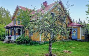 uma casa amarela com uma árvore em frente em 5 Bedroom Lovely Home In Fgelfors em Fåglebo