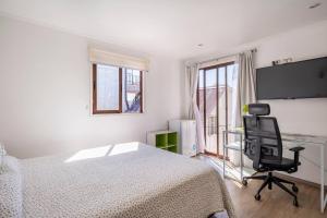 a bedroom with a bed and a desk and a chair at Habitaciones Valparaiso in Valparaíso