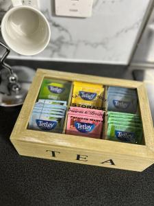 a wooden box filled with packets of toothpaste at Manchester Etihad Stadium Apartment by Daley Stays in Manchester