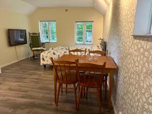 a dining room with a table and chairs and a bed at Lyrkroken in Vittsjö