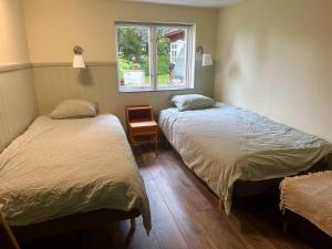 twee bedden in een kamer met een raam bij Lyrkroken in Vittsjö