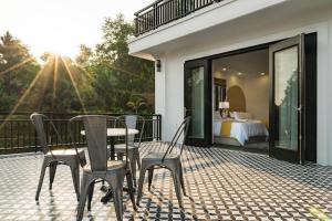 a patio with a table and chairs and a bedroom at Orestay Garden Hạ Long in Ha Long