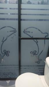 un bagno con due delfini dipinti su una finestra di Estadia Regalo de Dios 