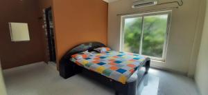 a bedroom with a bed in front of a window at Le Grace Kovalam in Chennai