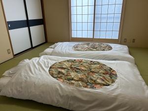 um grupo de três camas num quarto em Guest House Fuji no Yado Akebono Building A - Vacation STAY 74316v em Fujiyoshida