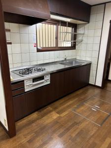 uma cozinha com um fogão e um lavatório em Guest House Fuji no Yado Akebono Building A - Vacation STAY 74316v em Fujiyoshida