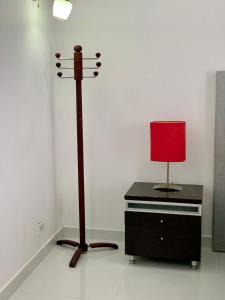 a red lamp on a stand next to a dresser at Apartaestudio en cartagena COLOMBIA in Cartagena de Indias