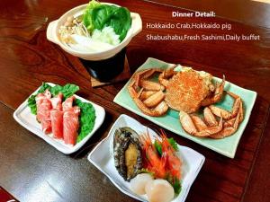 uma mesa com três pratos de comida e uma bebida em ニャー助のホテルん em Shakotan