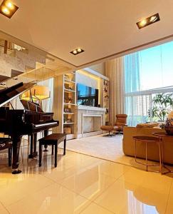 uma sala de estar com um piano e uma lareira em Apto de Alto Luxo Duplex - Centro (área nobre) em Chapecó