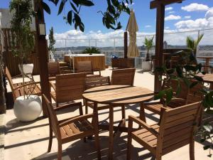 a patio with a wooden table and chairs at Apto de Alto Luxo Duplex - Centro (área nobre) in Chapecó