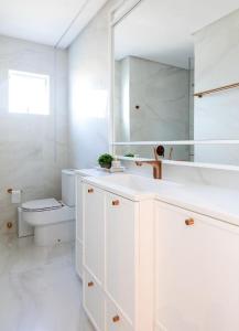 a white bathroom with a sink and a toilet at Apto de Alto Luxo Duplex - Centro (área nobre) in Chapecó