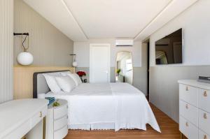 um quarto com uma cama branca e um espelho em Apto de Alto Luxo Duplex - Centro (área nobre) em Chapecó