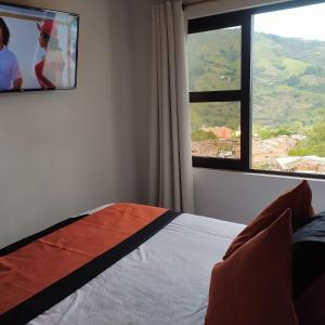 麦德林El Balcón De Las Montañas的一间带床和大窗户的卧室