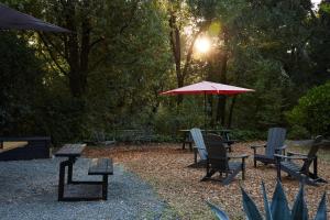 a group of chairs and tables with a red umbrella at Mine and Farm, The Inn at Guerneville, CA in Guerneville
