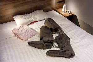 a pair of boots are laying on a bed at Far East Village Hotel Tokyo Ariake in Tokyo