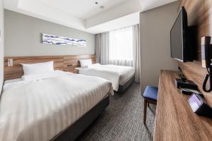 a hotel room with two beds and a flat screen tv at Far East Village Hotel Tokyo Ariake in Tokyo