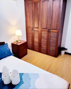 a bedroom with a bed and a wooden cabinet at Cozy 2BR with FREE Pool beside SM City Mall in Davao City