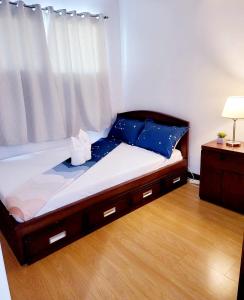 a bed in a room with a wooden floor at Cozy 2BR with FREE Pool beside SM City Mall in Davao City