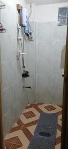 y baño con ducha y alfombra azul. en Mavy's Maligcong Homestay en Bontoc