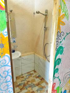 uma casa de banho com um chuveiro e um lavatório. em Forest Camp El Nido em El Nido