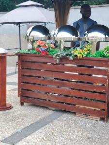 a wooden dresser with flowers on top of it at Casa Consuelo Guest House in Takoradi