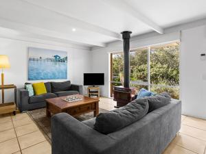 a living room with a couch and a tv at Quarterdeck in Portsea